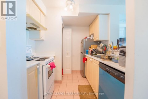 A small, clean kitchen with white appliances and wooden cabinets.