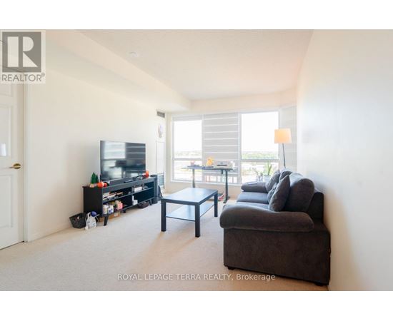 A living room with a couch, a coffee table, and a television.