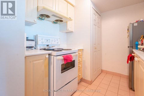 A kitchen with a white oven and a white fridge.