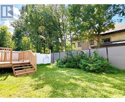 A backyard with a wooden deck and a fence.