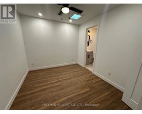 A room with wooden flooring and a ceiling fan.