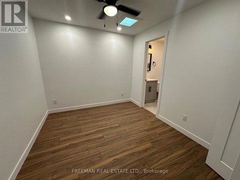 A room with wooden flooring and a ceiling fan.