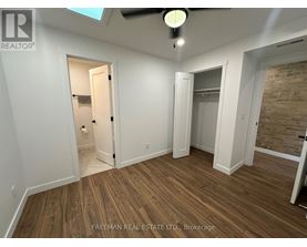 A room with wooden flooring and a ceiling fan.