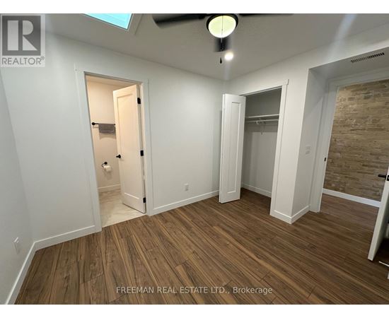A room with wooden flooring and a ceiling fan.