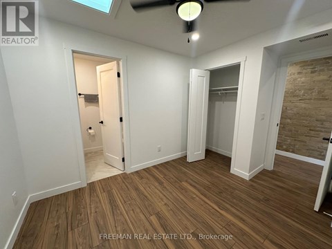 A room with wooden flooring and a ceiling fan.