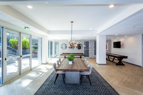 A modern dining room with a long table and chairs.