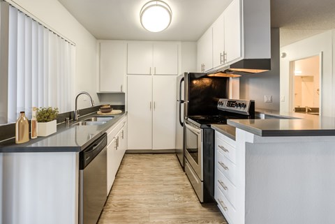 A modern kitchen with white cabinets and stainless steel appliances.