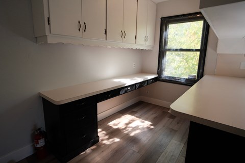 A kitchen with white cabinets and a black counter.