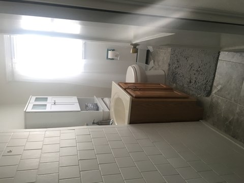 A bathroom with a toilet, sink, and tiled floor.