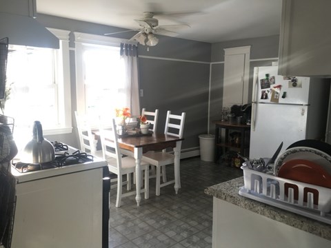 A kitchen with a table and chairs.