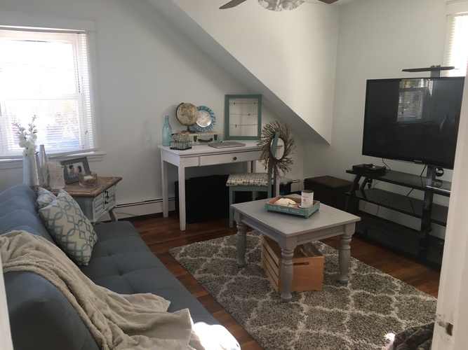 A living room with a grey couch and a grey coffee table.