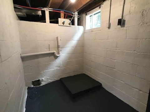 A room with white walls and a black mat on the floor.