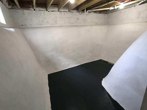 A room with a white wall and a black floor.