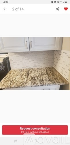 A close-up of a kitchen counter with a patterned tile backsplash.