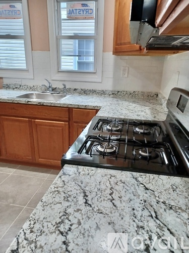 A kitchen with a granite countertop and a stove top oven.
