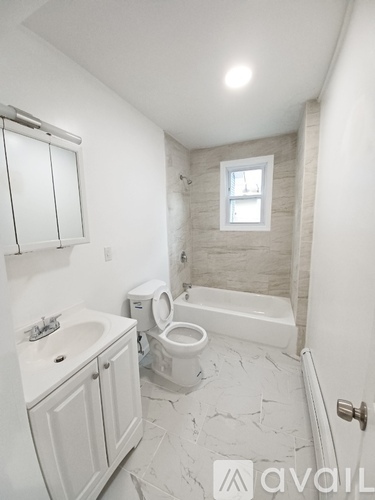 A bathroom with a toilet, sink, and bathtub.