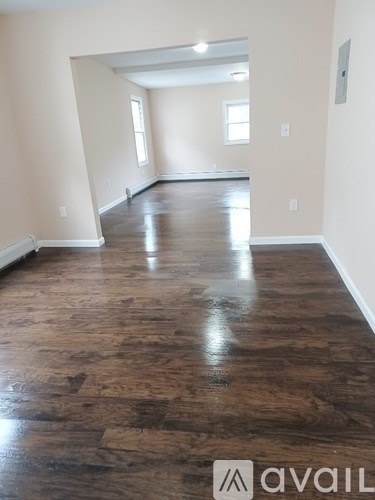 A room with wooden flooring and a logo that says "avaiL" on the bottom right.
