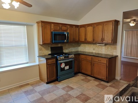 A kitchen with wooden cabinets and a black stove top oven.