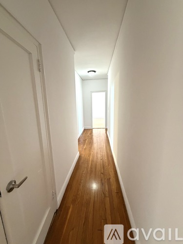 A room with wooden floors and a window with a white frame.