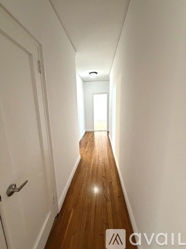 A room with wooden floors and a window with a white frame.