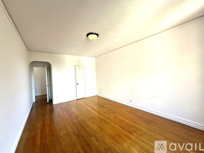 A room with wooden floors and two white doors.