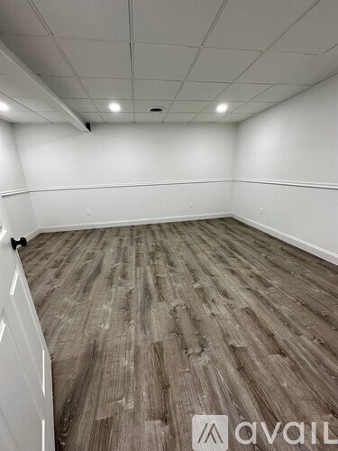 A room with wooden flooring and white walls.