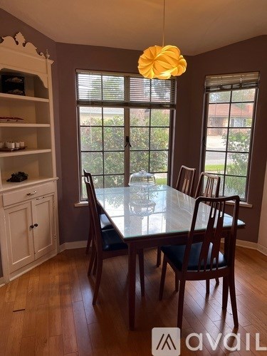 A dining room with a table and chairs.