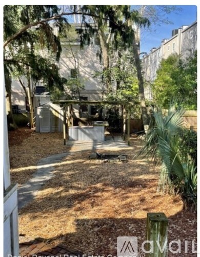 A garden area with a white building in the background.