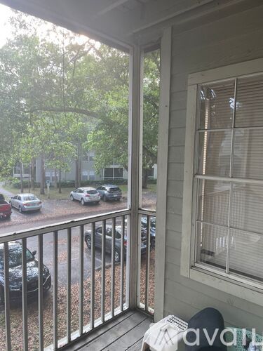 A balcony with a view of cars and trees.