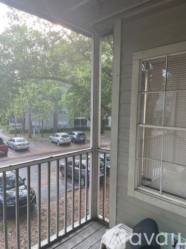 A balcony with a view of cars and trees.