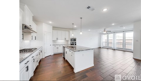A spacious kitchen with white cabinets and a central island.