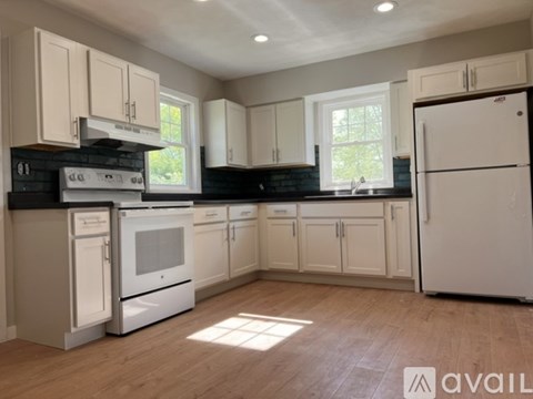 A kitchen with white appliances and cabinets.