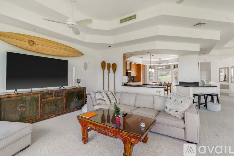 A living room with a white couch and a wooden coffee table.