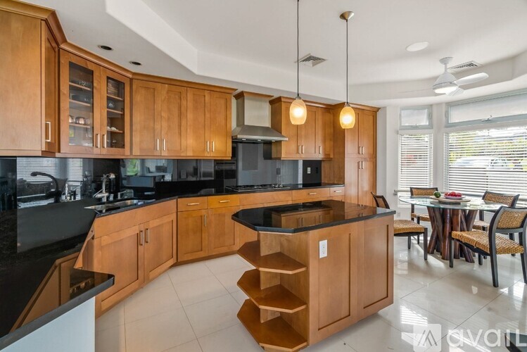 A kitchen with wooden cabinets and black countertops.