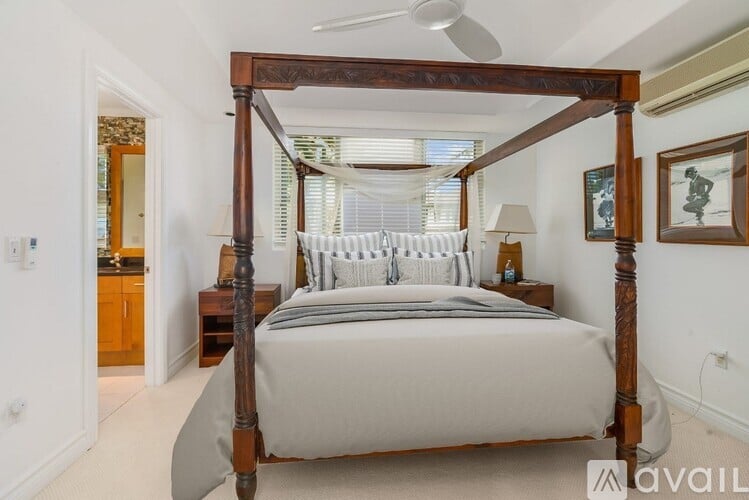 A bedroom with a four-poster bed and a ceiling fan.