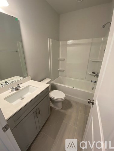 A bathroom with a toilet, sink, and bathtub.
