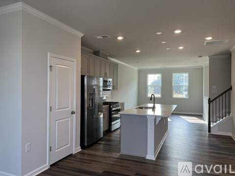 A kitchen with a refrigerator, sink, and cabinets.