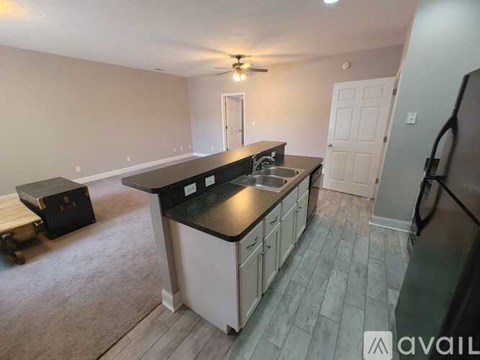 A kitchen with a black countertop and white cabinets.