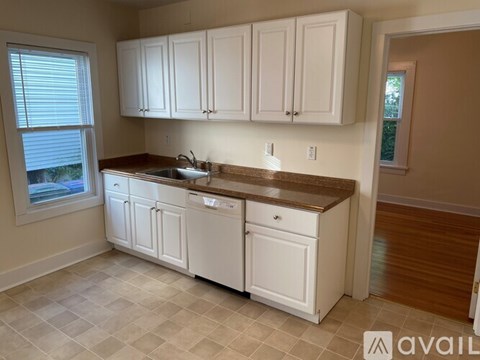 A kitchen with white cabinets and a brown countertop.