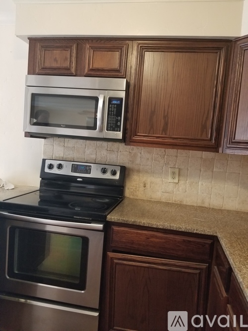 A kitchen with a stove top oven and microwave above it.