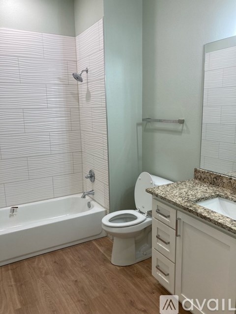 A white bathroom with a tub, toilet and sink.