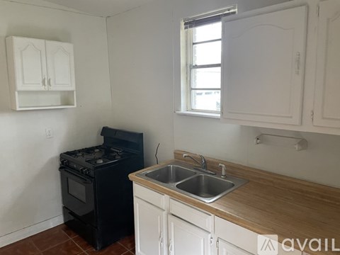 A kitchen with a black stove and white cabinets.