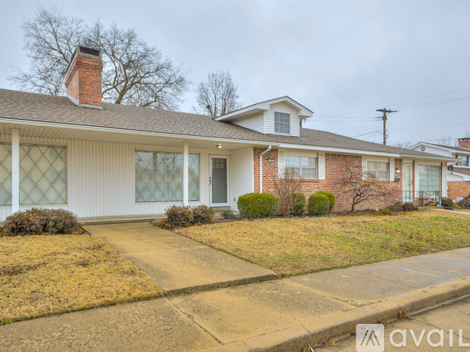 A house with a brick chimney and a white exterior is for sale.