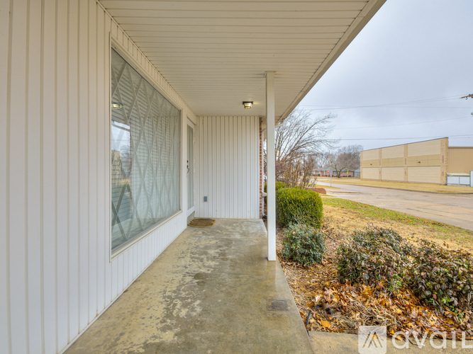 A white building with a concrete floor and a white wall.