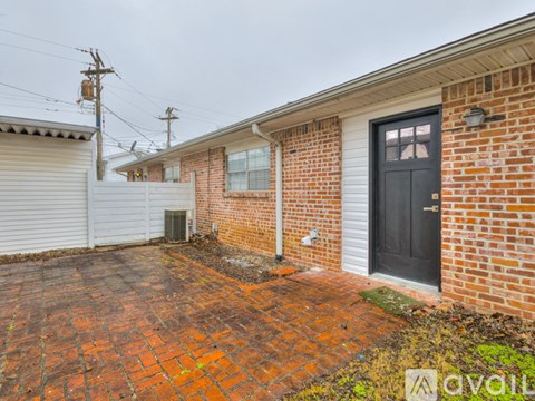 A brick house with a black door and a white garage door.