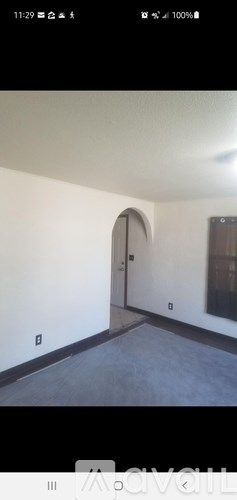 A room with a white wall and a brown arched doorway.
