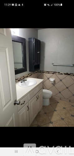 A bathroom with a toilet, sink, and mirror.