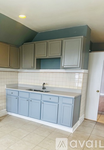 A kitchen with blue cabinets and a white sink.