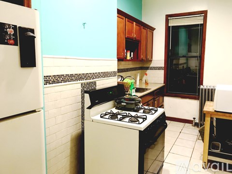 A kitchen with a white fridge and a black stove.
