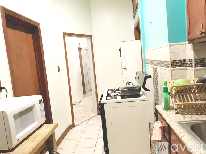 A kitchen with a stove, microwave, and refrigerator.
